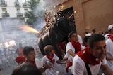 Revellers run from the "Fire Bull" on the second day of the festival in Pamplona