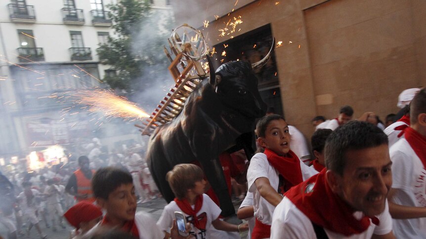 Revellers run from the "Fire Bull" on the second day of the festival in Pamplona