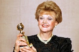 Angela Lansbury holds up her Golden Globe Award