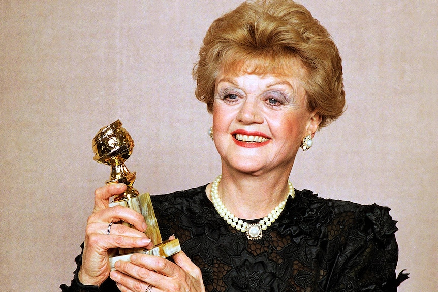 Angela Lansbury holds up her Golden Globe Award