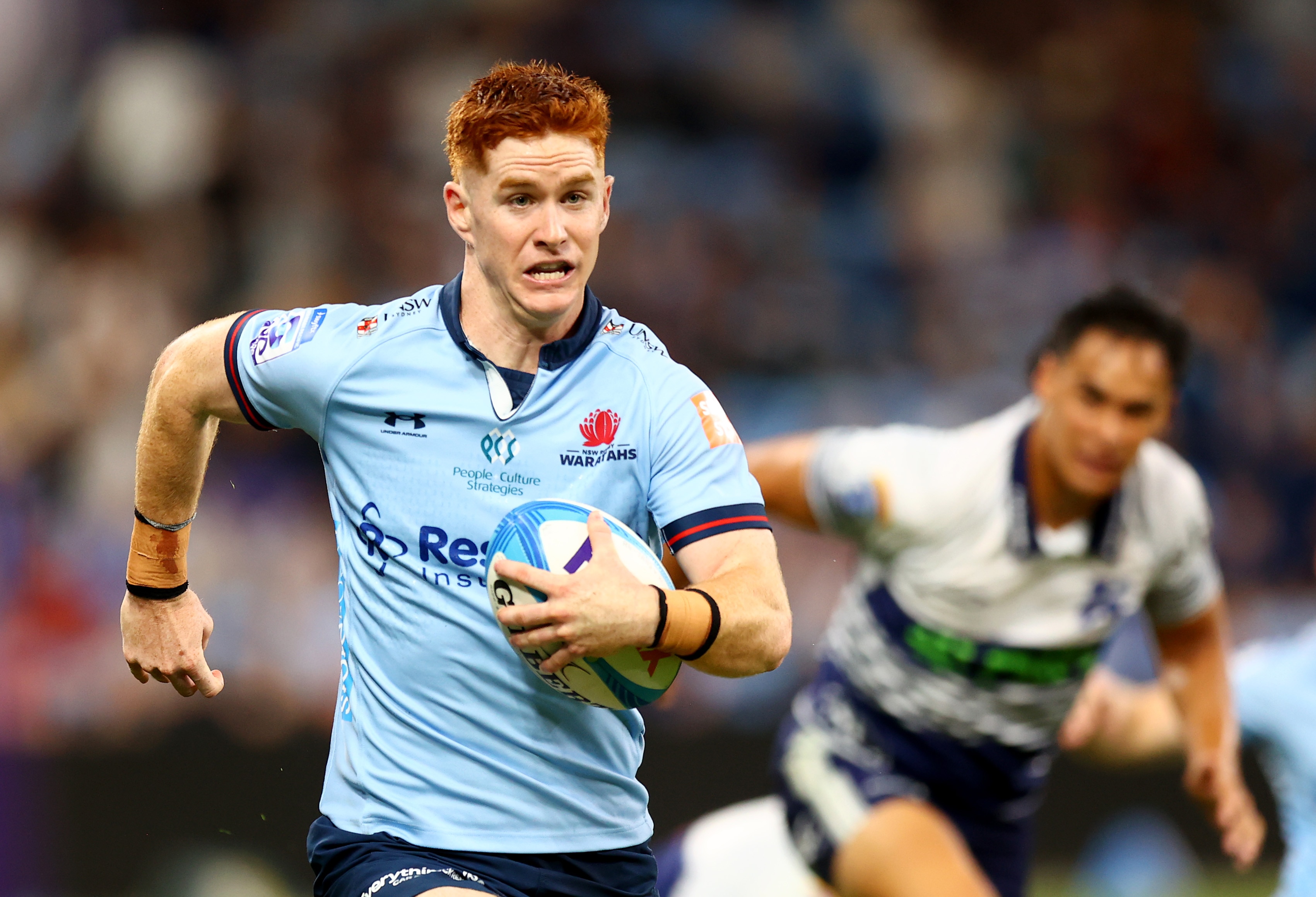 Sid Harvey corre com a bola debaixo do braço esquerdo pelos Waratahs contra os Blues.