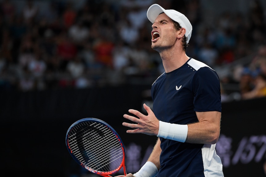 Andy Murray grimaces on court, clenching his hand in frustration after losing a point