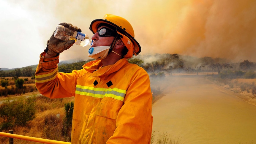 A CFA firefighter has a drink as he takes a break while fighting a bushfire at the Bunyip State Forest Saturday, Feb. 07, 2009.