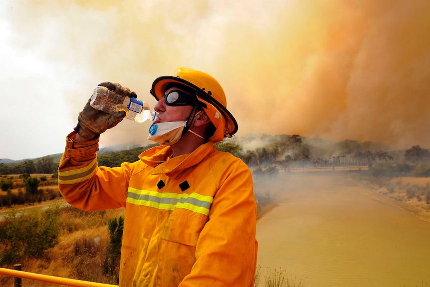 A CFA firefighter has a drink as he takes a break while fighting a bushfire at the Bunyip State Forest Saturday, Feb. 07, 2009.