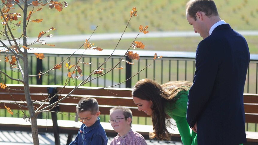 The Duke and Duchess of Cambridge are helped by two children as they plant a tree at the National Arboretum.