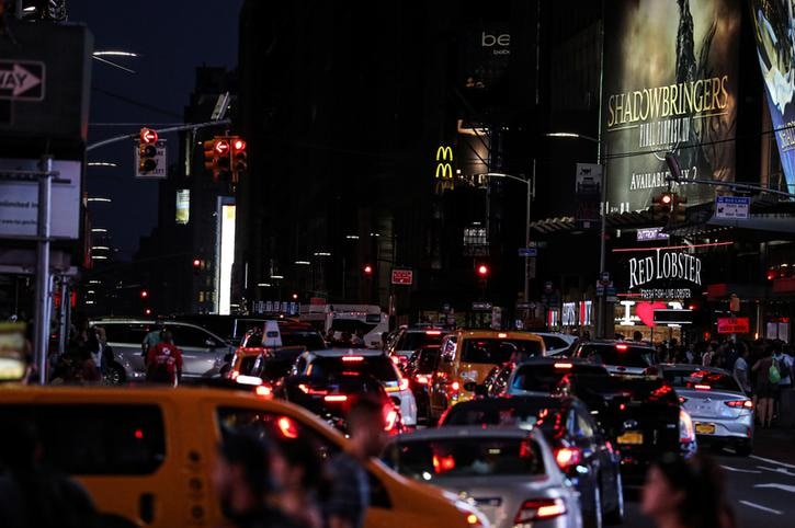 Cars and yellow taxis are banked up near Times Square, with the majority of displays shrouded in darkness.