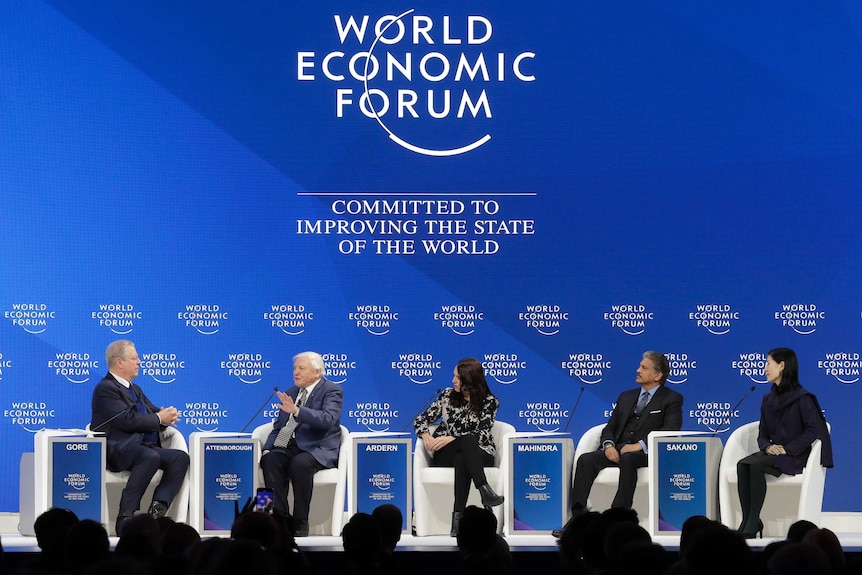 Five of the world's political elites sit in front of a World Economic Forum sign in Davos, Switzerland.