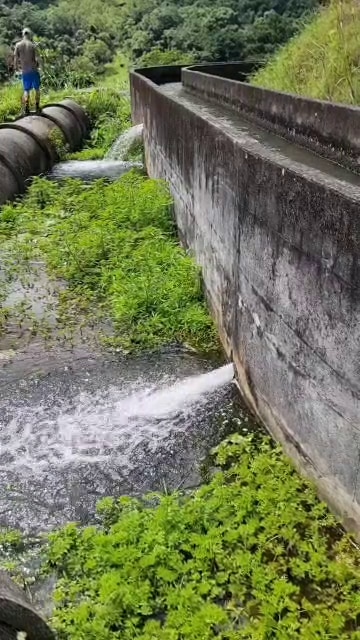 Water bursts from two points in a long concrete flume.