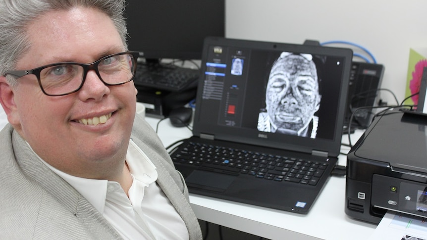 Professor Michael Kimlinsits in front of UV camera on a desk.