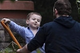Joshua Boyle and one of his kids play in the garden at his parents house.