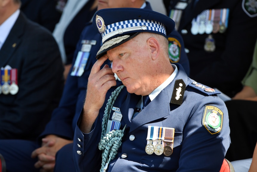 nsw police commissioner mick fuller in formal police wear scratching his brow