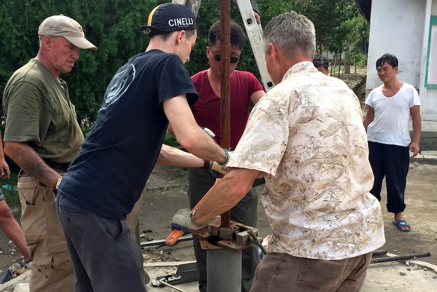 Volunteers repair a water pump in North Korea