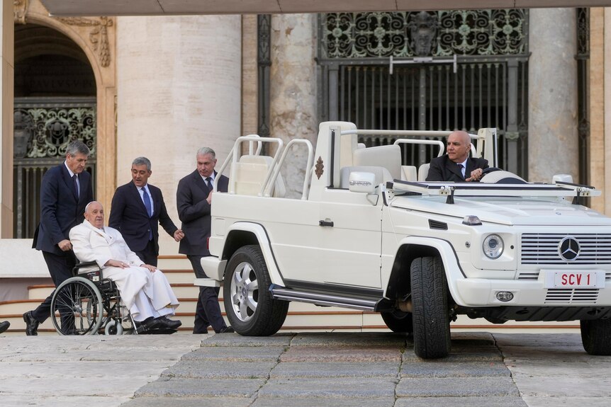 Pope Francis leaves at the end of his weekly general audience in St. Peter's Square he is wheeled near white mercedes