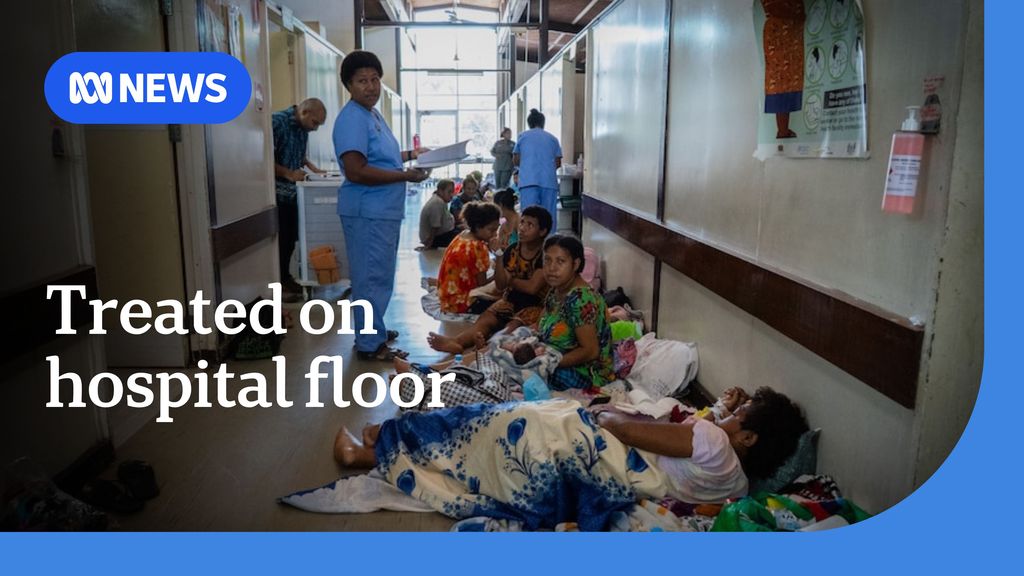 Treated on hospital floor: Women sit on the floor of a hospital corridor holding their newborn babies
