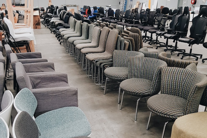 Different types of office chairs in rows in a warehouse