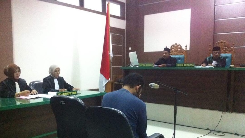 A man holds his head in his hands as he faces the Banda Aceh Sharia District Court on May 17, 2017.