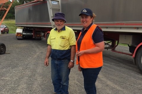 Two people in high vis vests standing near a truck