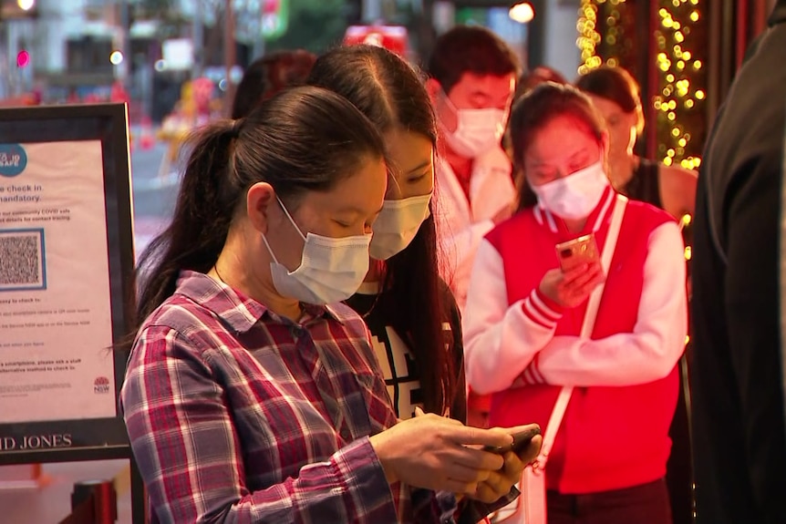 Buyers line up with face masks