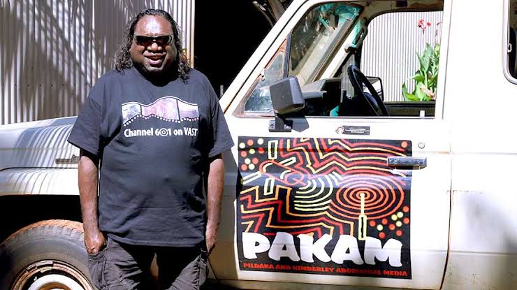 Hombre indígena se para frente a un coche 