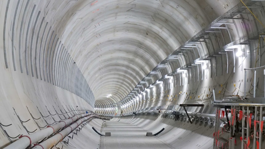 Interior of a wide tunnel sealed with cement but still under construction.