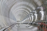 Interior of a wide tunnel sealed with cement but still under construction.