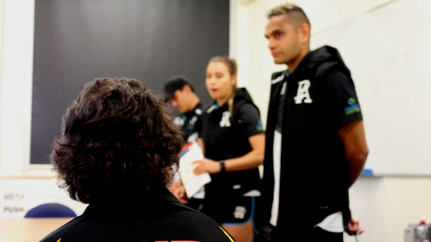 A Mount Gambier High School Student watches AFL players give a speech.