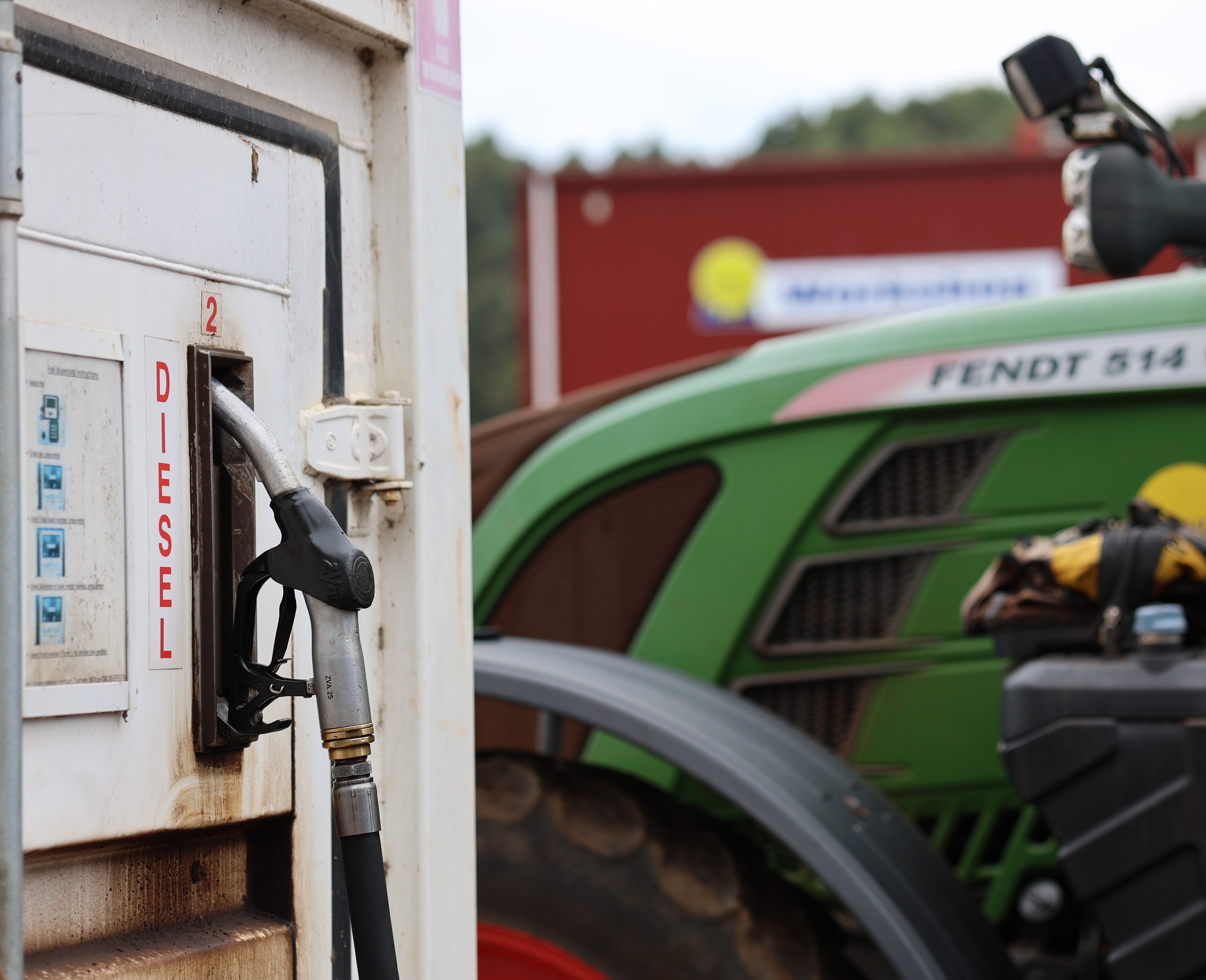a tractor is parked next to a diesel fuel pump