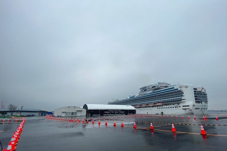 A ship docked in an area marked by orange construction cones