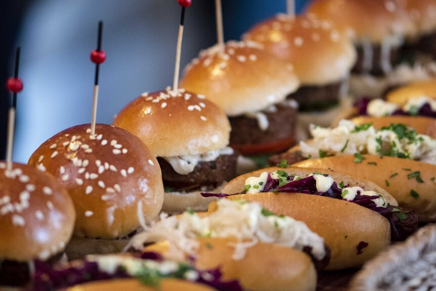 mini burgers with toothpicks in the buns
