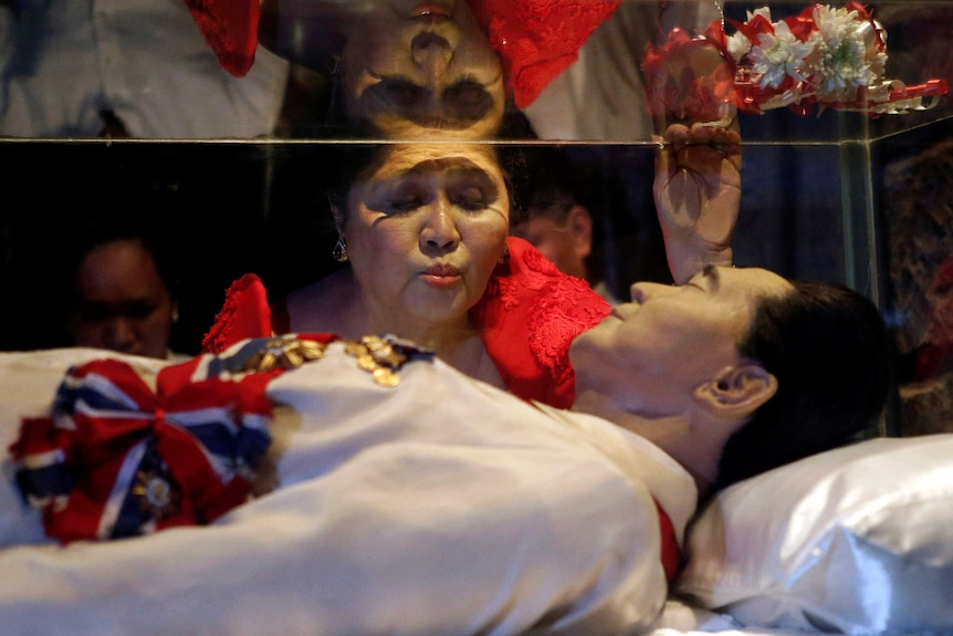Widow kisses glass coffin of embalmed body of Ferdinand Marcos