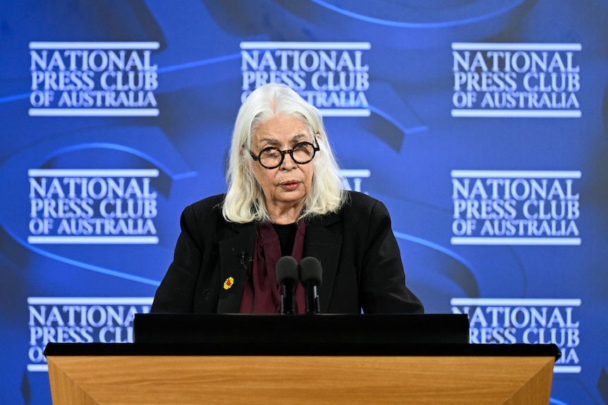 Marcia Langton speaks at a lectern with microphones