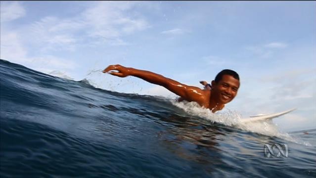 Smiling man on surfboard in ocean