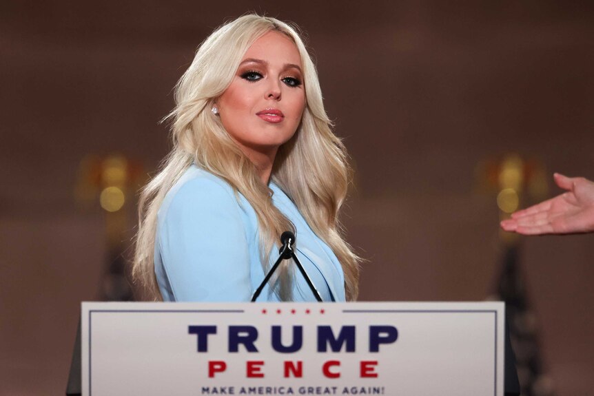 Tiffany Trump in a light blue suit standing at a lectern