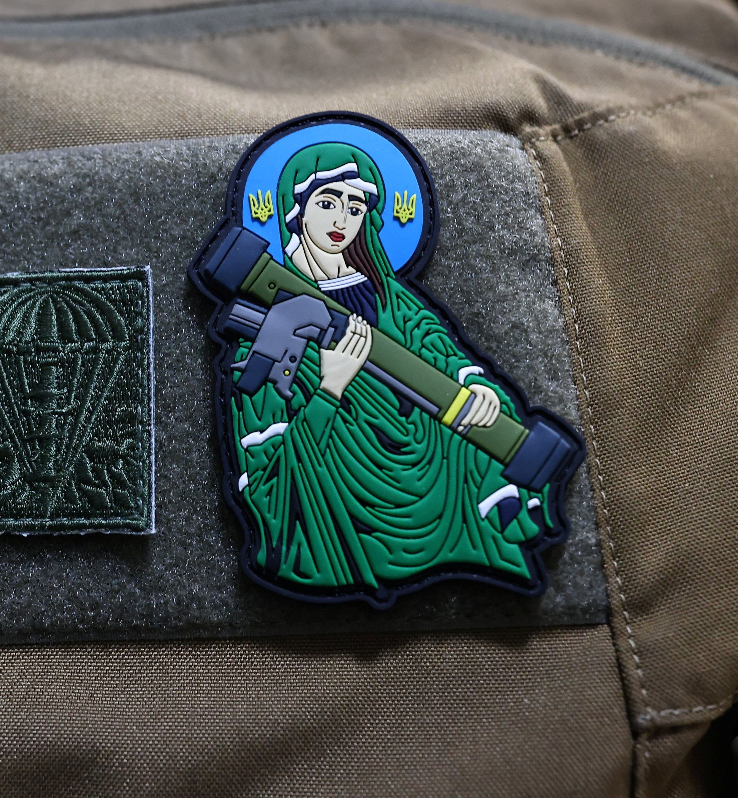 A patch on a US army uniform depicting the Virgin Mary holding a rocket launcher 
