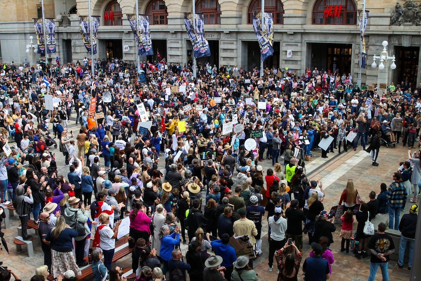 About 1,000 people rally in Perth with some holding signs opposing vaccine passports and mandatory COVID vaccinations.