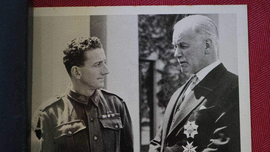 Old photo of man in medals meeting government official.