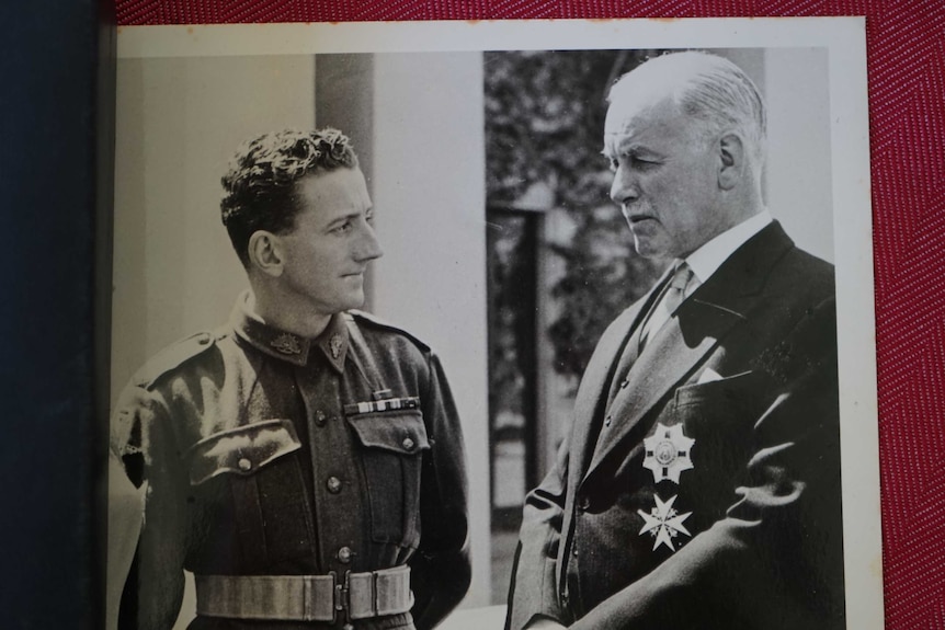 Old photo of man in medals meeting government official.