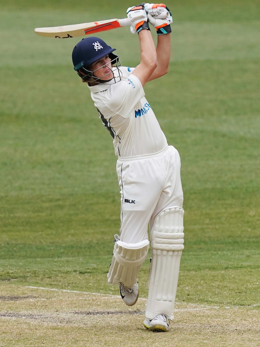 A Victorian batter watches a shot with his bat positioned above his left shoulder during a Sheffield Shield match at the MCG.