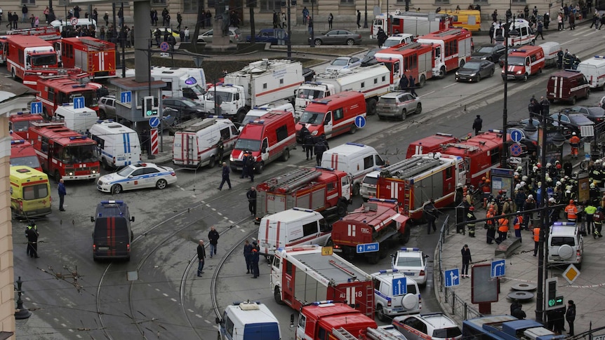 A general view from above shows many ambulances, fire trucks and authorities outside a metro station.