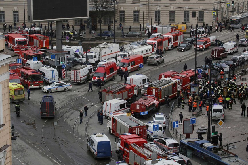 A general view from above shows many ambulances, fire trucks and authorities outside a metro station.