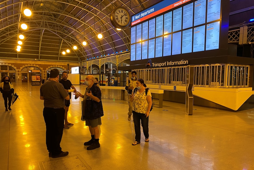 A man gestures to a train staff member