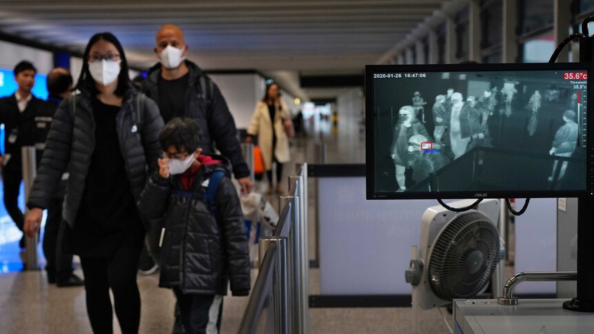 Health surveillance officers use a temperature scanner to monitor passengers arriving at Hong Kong International Airport.