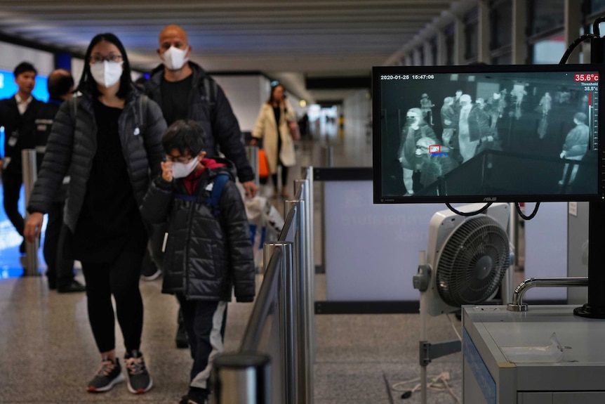 Health surveillance officers use a temperature scanner to monitor passengers arriving at Hong Kong International Airport.