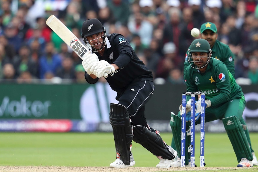 A batsman clips a shot through midwicket, as he and the wicketkeeper watch the ball  in flight.