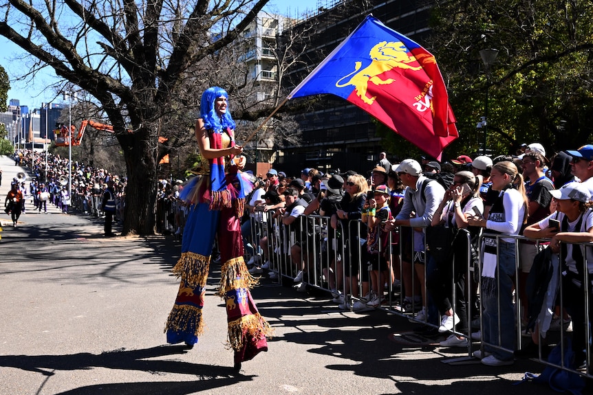 a stilt walker dressed in the brisbane lion colours takes part in the afl grand final parade on friday september 29