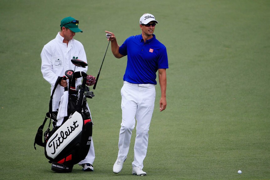 Improved showing ... Adam Scott walks on the second hole alongside his caddie Mike Kerr