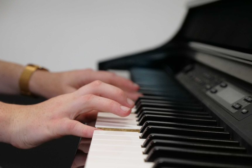 a close-up photo of a girl's hands playing the keys of a piano