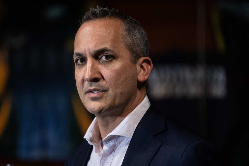 Andrew Abdo in a suit and white shirt looks toward the camera