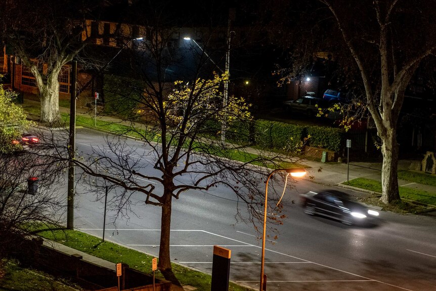 a street at nighttime with a blurred car