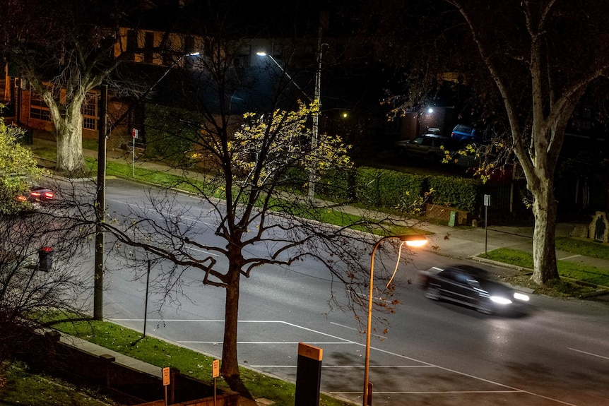 a street at nighttime with a blurred car